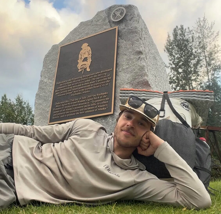 guy lying down ibn front of stone monument