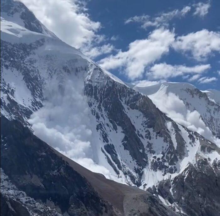 An avalanche swepts a face of Broad Peak.