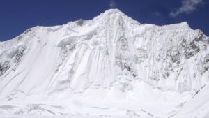 A mountain face of flutted snow and ice.