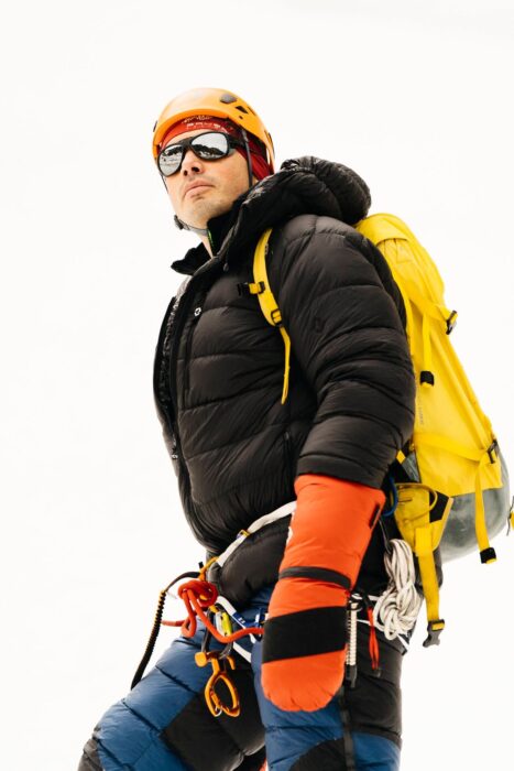 Bodyshot of Lukas Supergan dressed in alpinism clothes. 