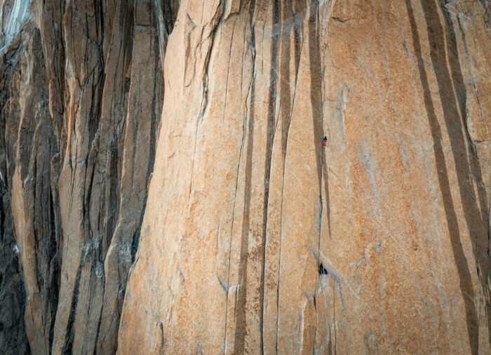 A tiny-looking climber on a massive, vertical granite wall. 