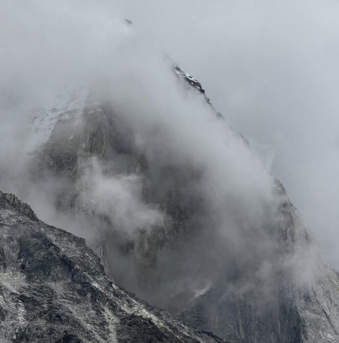Clouds wrapping a rock mountain face. 