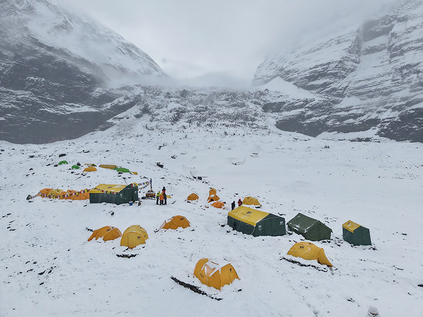 Tents on a snowy Dhaulagiri Base Camp, Dhaulagiri col in background.