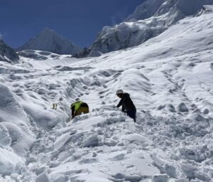 Sherpas dig out among loads of snow in sunny weather.