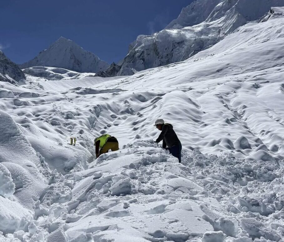 Sherpas dig out among loads of snow in sunny weather.