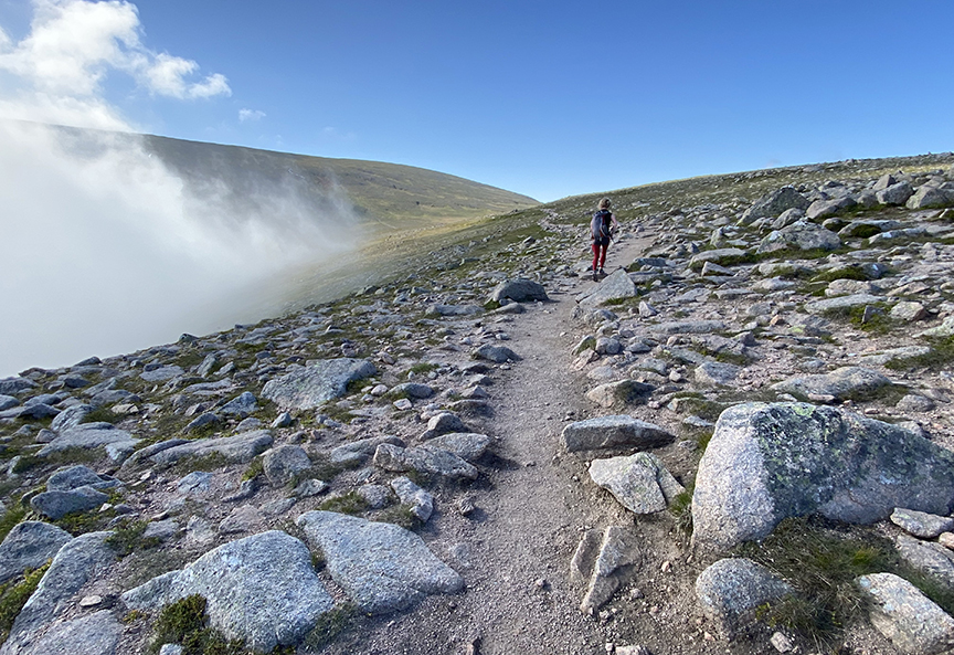 hiker in a mix of sun and fog