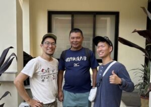 Japanese climbers in casual wear at the gate f a house..