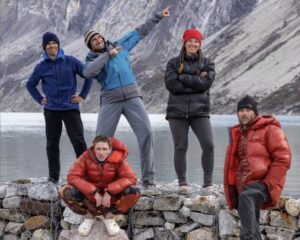 Climbers posing by a lake.
