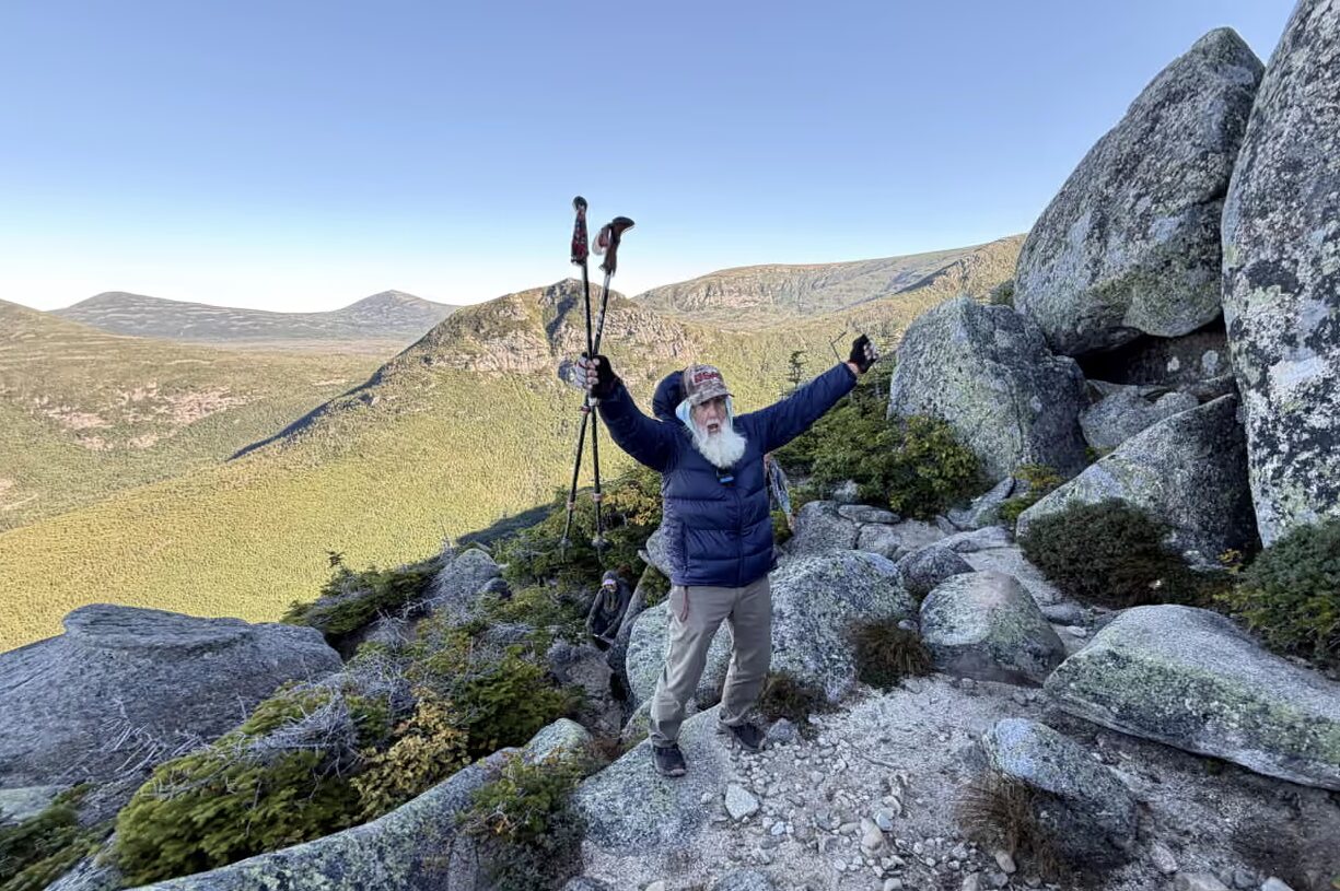Dale Sanders put his arms in the air and celebrates after hiking a difficult section of Mt Katahdin in Maine. Photo: Robert F Bukaty