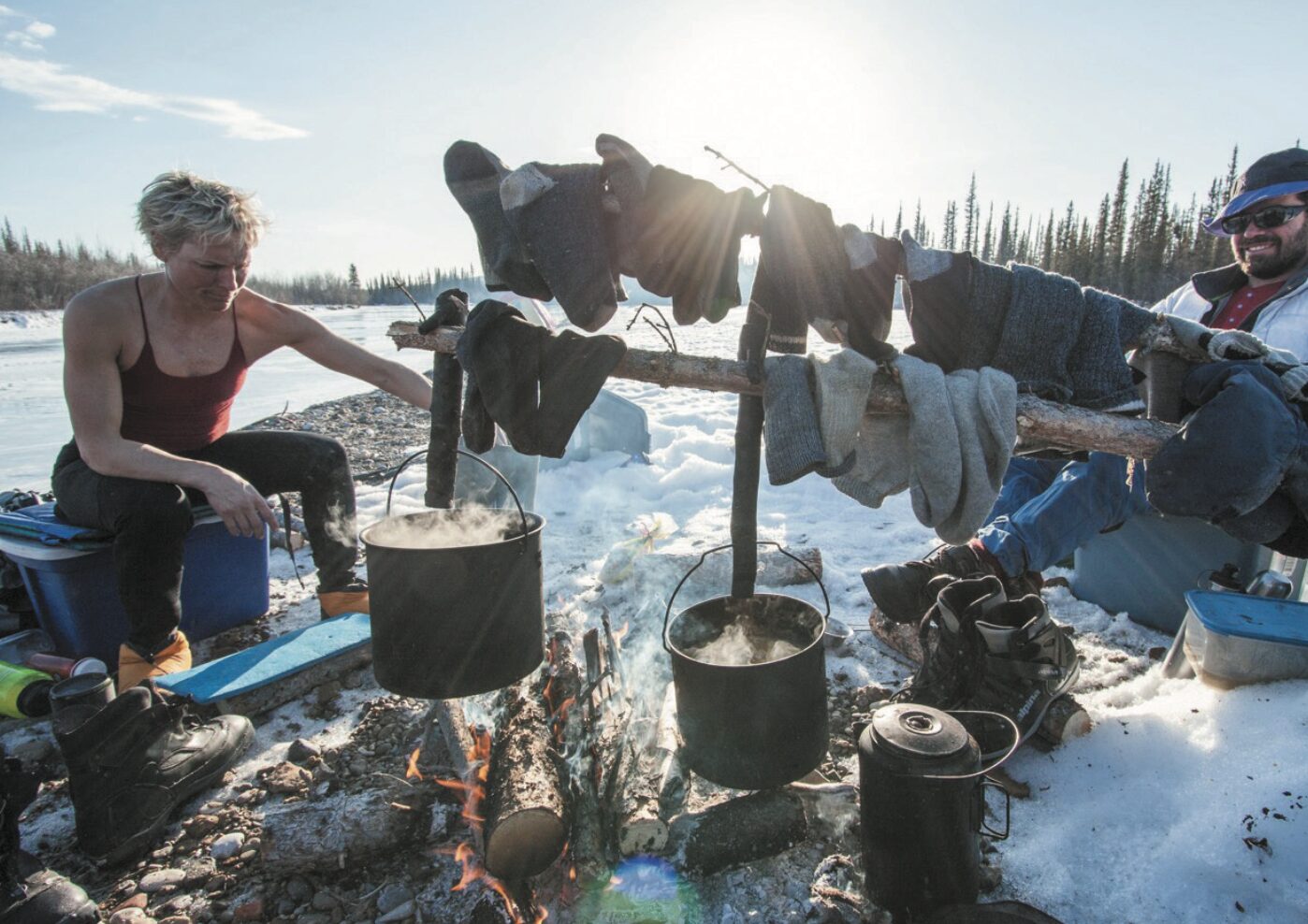 Two people camping with a fire in the Yukon