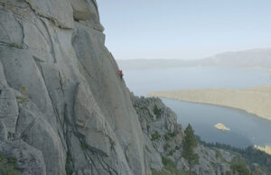 A man climbing up a cliffside with no ropes