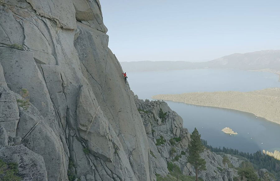 A man climbing up a cliffside with no ropes