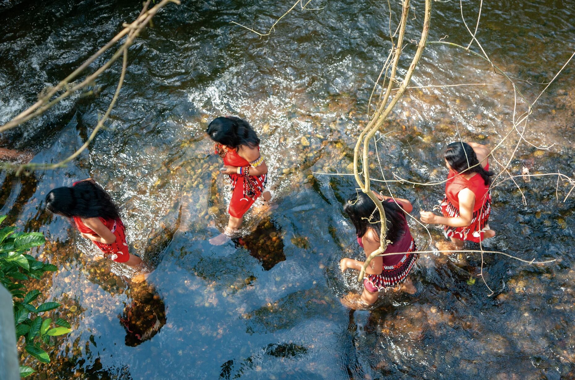 An aerial shot shoing women from the Awajún communities follow rivers for travel and fishing.