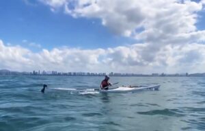 kayaker under blue sky, calm water