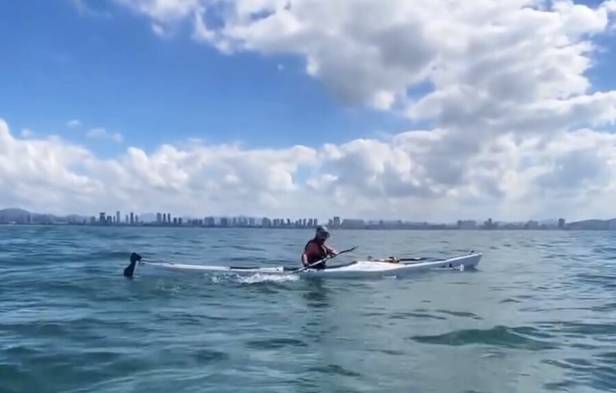 kayaker under blue sky, calm water