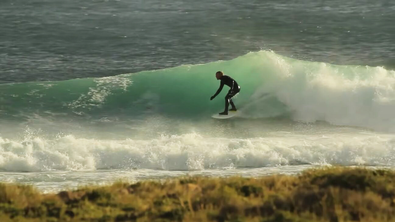guy in wetsuit surfing