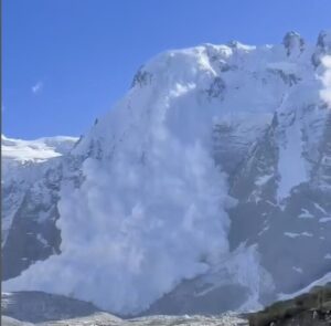 An avalanche falls down a cliff.