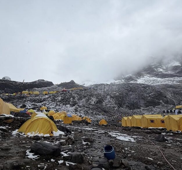 A rainy baase camp on dark morraine terrain.