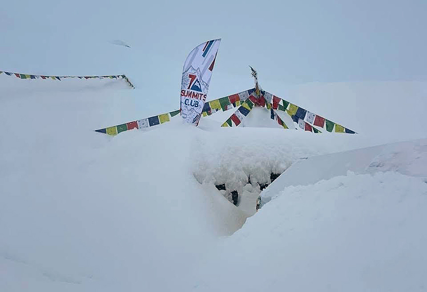 A Chorten and a tent buried in fresh snow.