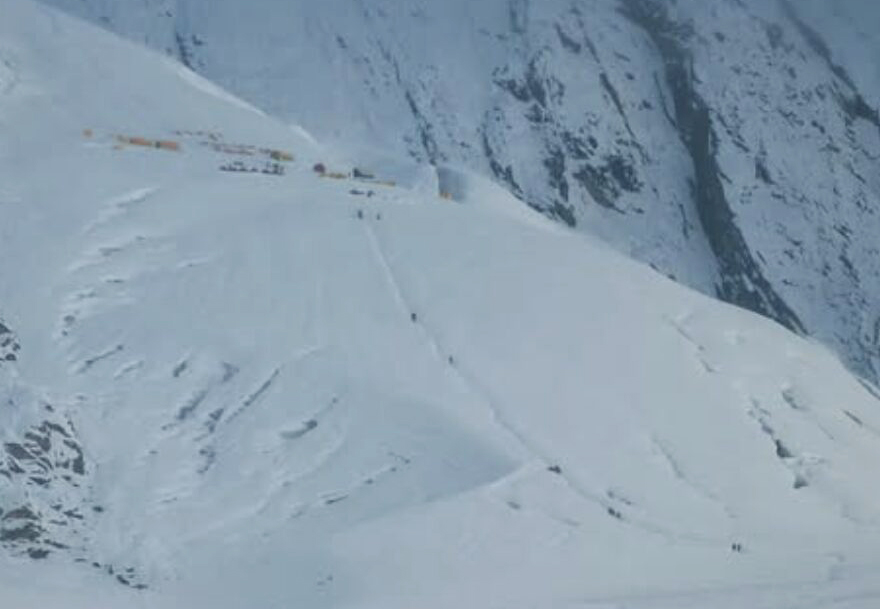 climbers on a trail on a snowy flank of Manaslu.
