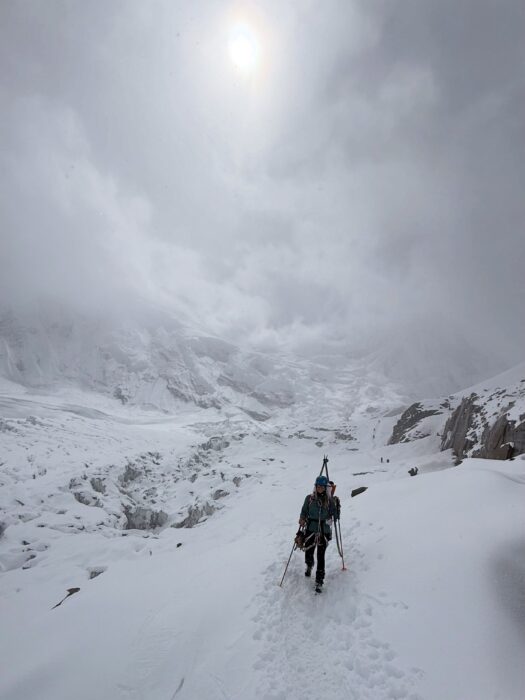A climber walking down Manaslu with skis strapped to his backpack. 
