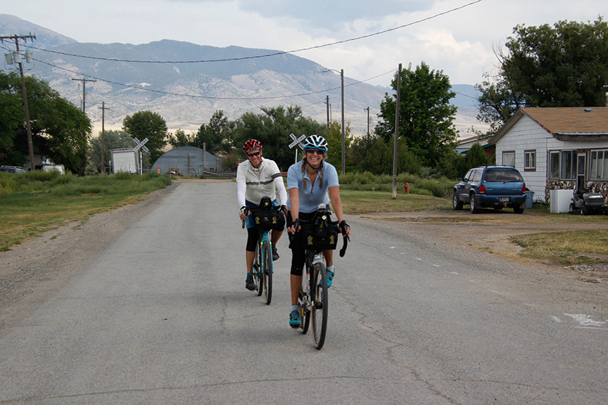 Jules Stennes and Patch Doyle cycling through a small town