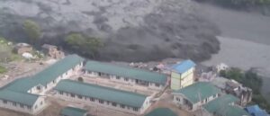 A flooded river sweeps through some houses in Nepal.