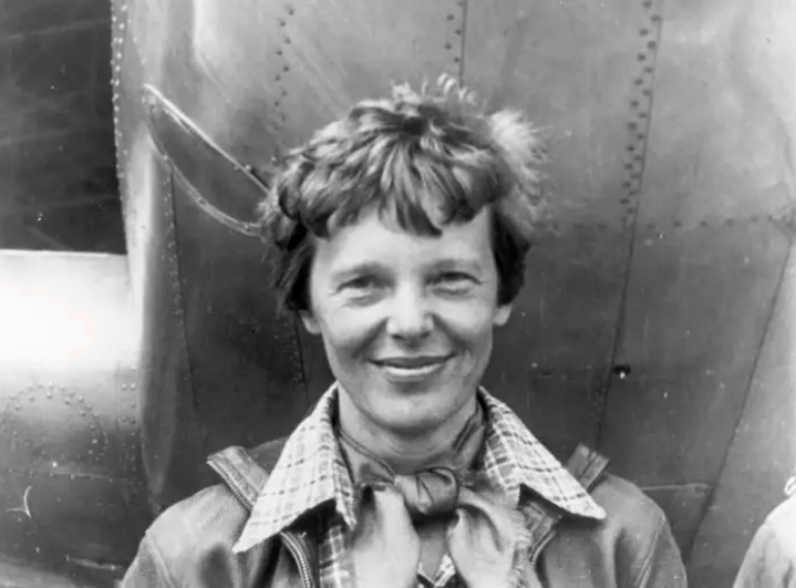 Amelia Earhart standing under nose of her Lockheed Model 10-E Electra. 1937. 