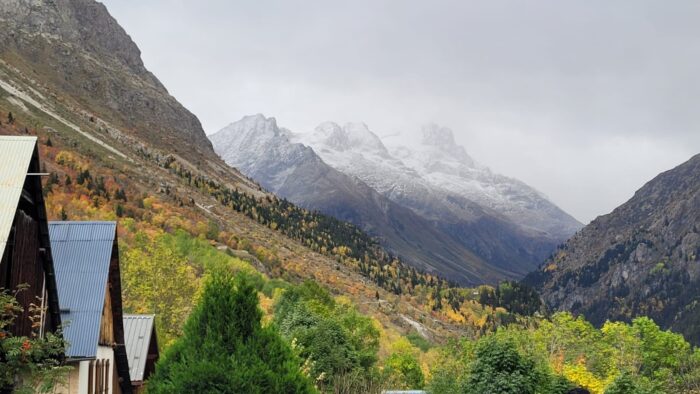 A mountain landscape in a foggy day, houses on the side. 