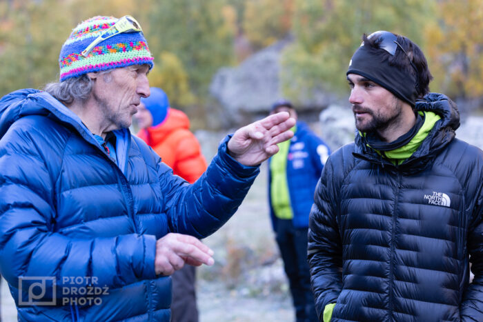 Two climbers chat in an outdoor setting. 