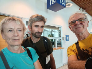 Three climbers take a selfie in an indoor setting in Kathmandu.