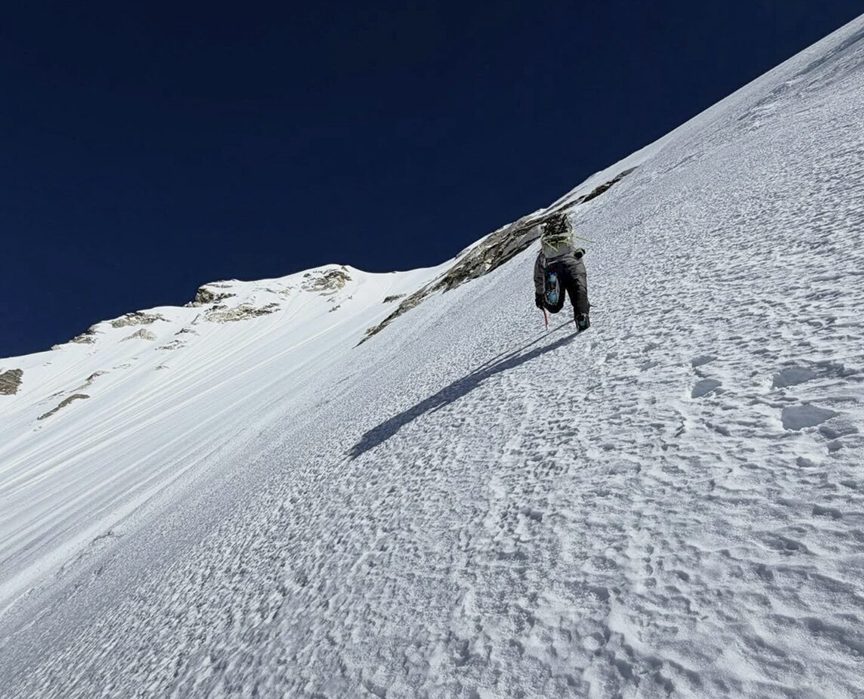 A climber on a steep, hard snow face.