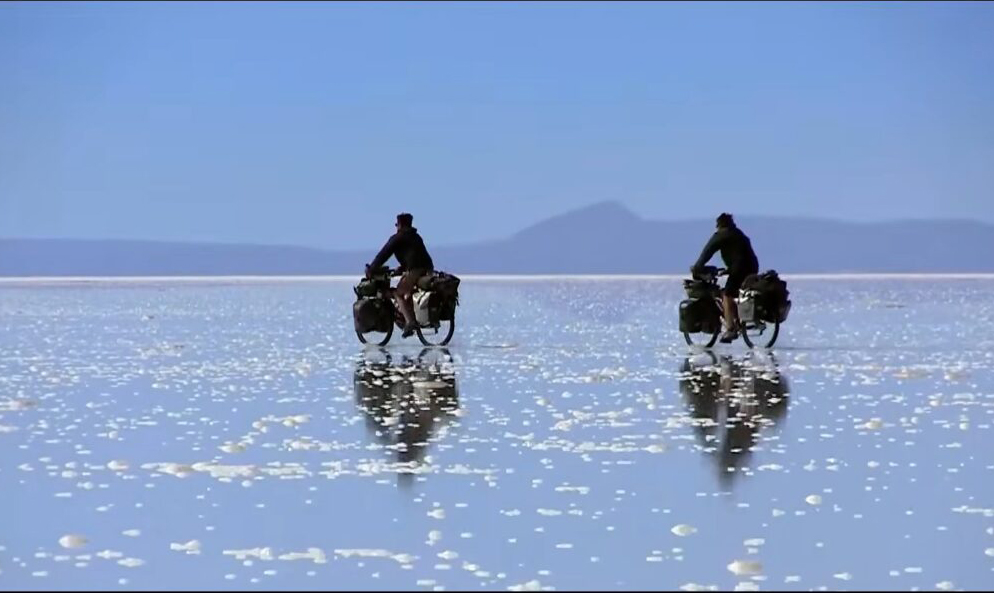 Two cyclists crossing a salt flat