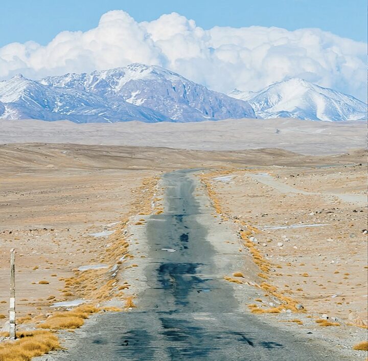 desertroad leading toward snowy mountains