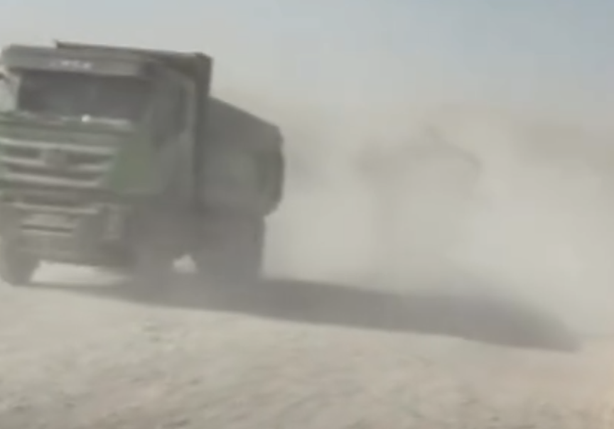 dusty road with truck