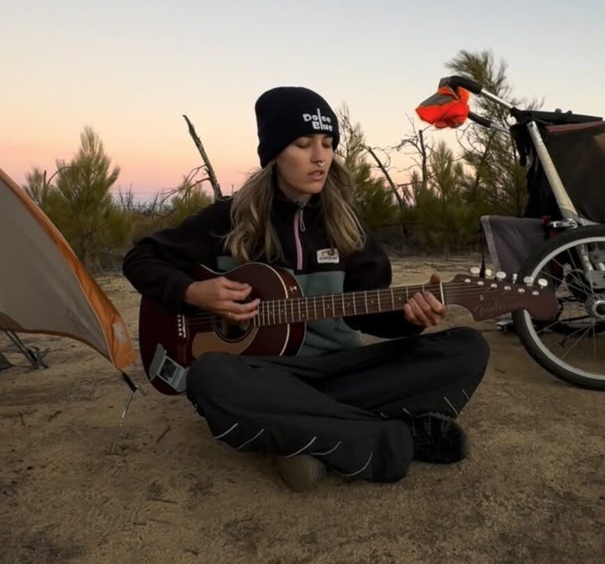 Birdgirl plays the guitar as she makes camp for the night.