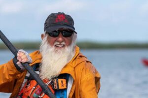 A close up portrait photo of Dale Sanders paddling the Mississippi River at age 87