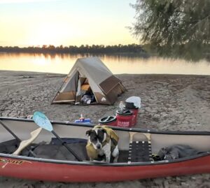 canoe campsite by river at sunset