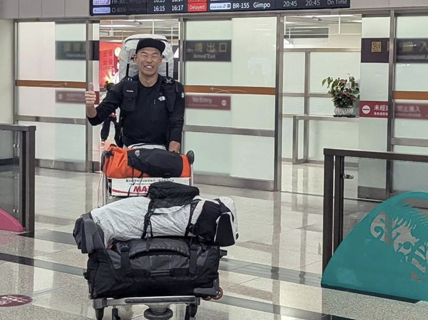 Japanese guy at airport with luggage cart