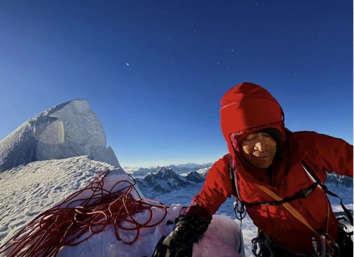 A climber on a spiky snow summit. 