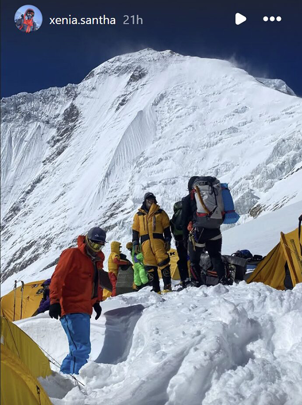 Climbers on a snow slope among tents.