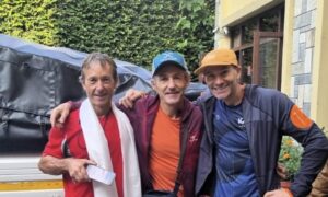 Three climbers pose outside an office in Kathmandu