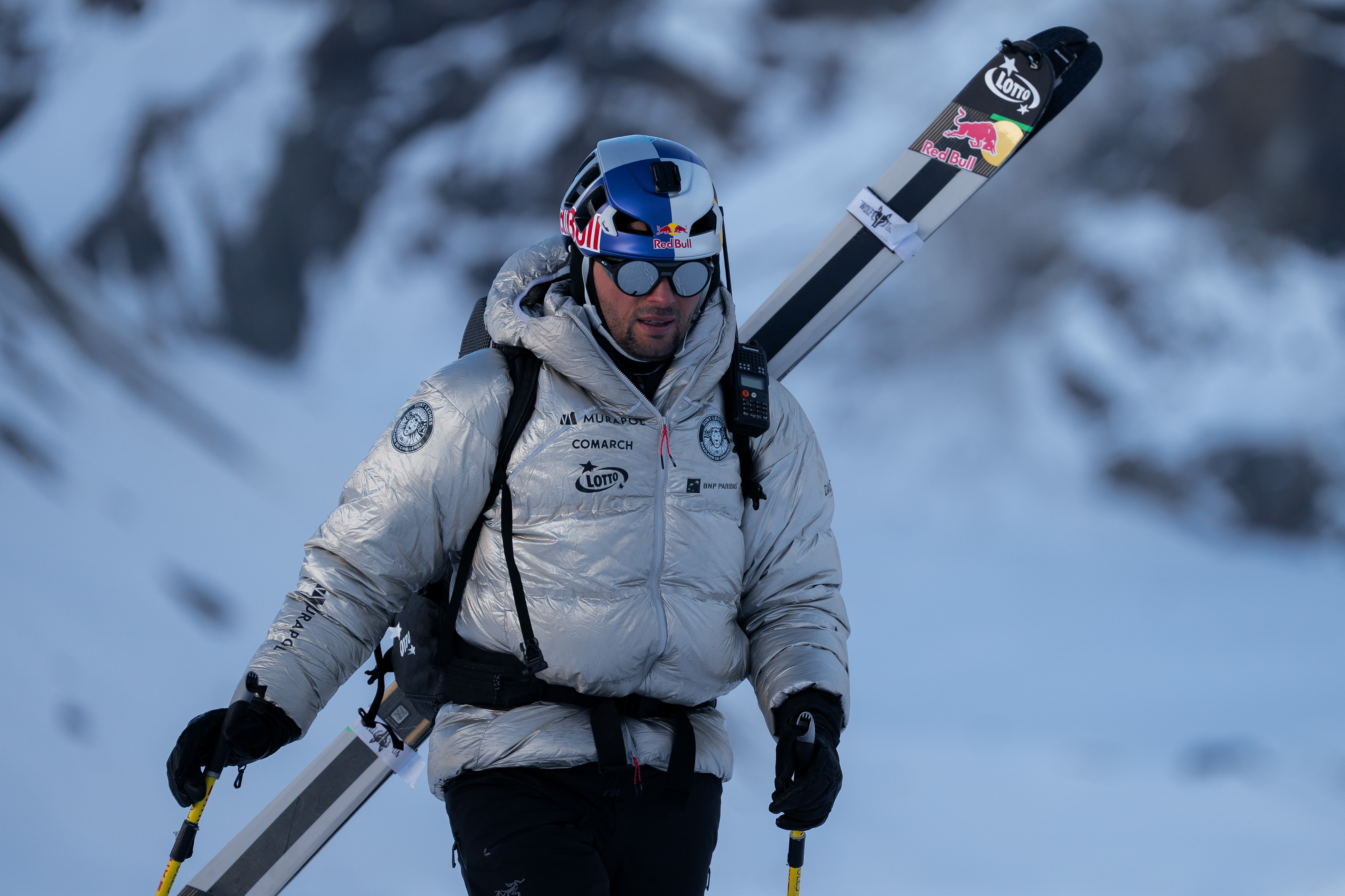 Bargiel with dawn jacker, helmet and skis strapped to backpack.