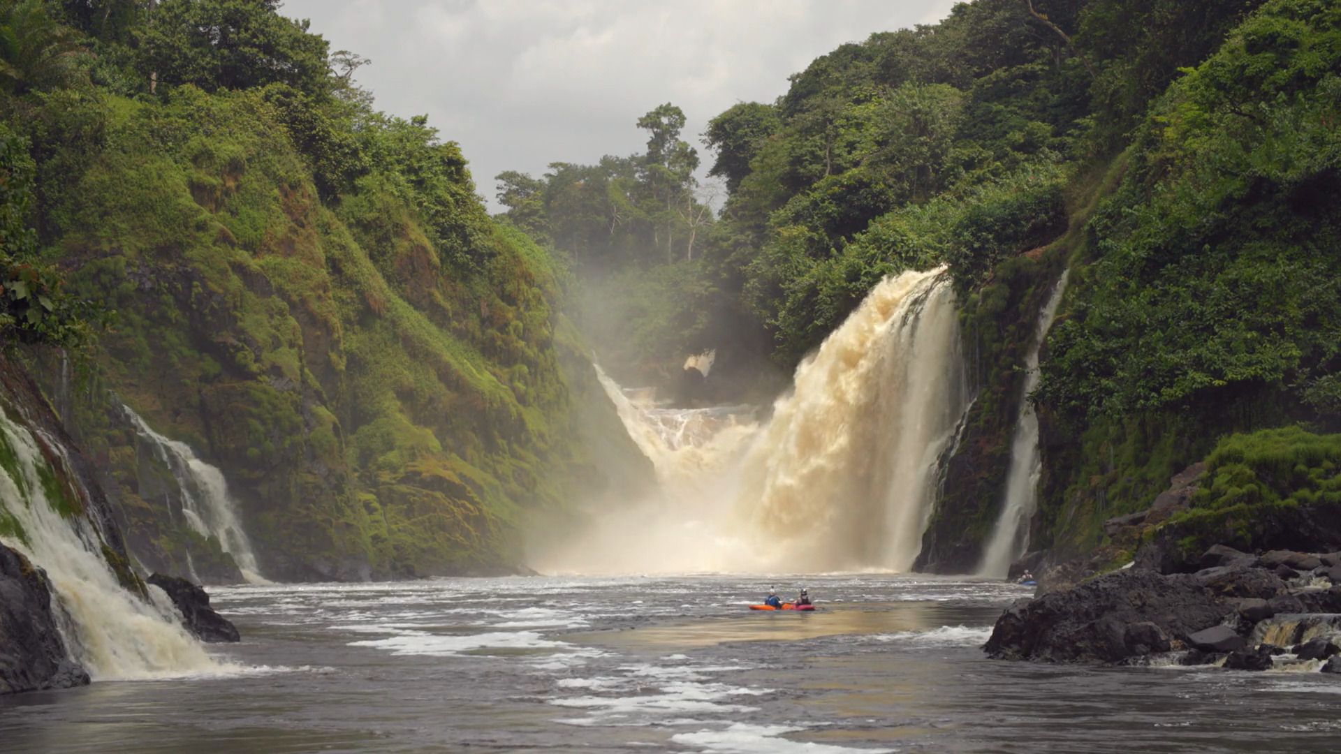 A waterfall, with kayakers in foreground